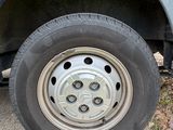 a blue truck with a flat tire parked on the side of the road