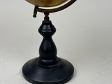a small globe that is on a stand on a white surface