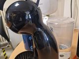 a coffee maker sitting on a table next to a glass of water