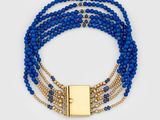 a close up of a bracelet with blue beads and a gold clasp