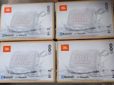 four boxes of jbl bluetooth speakers sitting on top of each other