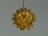 a gold sunburst hanging from the ceiling of a building