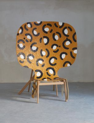 une chaise dont l'assise en bois est ornée d'un motif