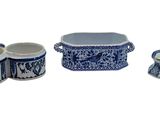 trois pièces de poterie bleue et blanche posées sur une surface blanche