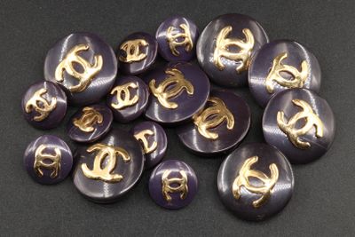 some purple buttons with gold letters are on a black surface