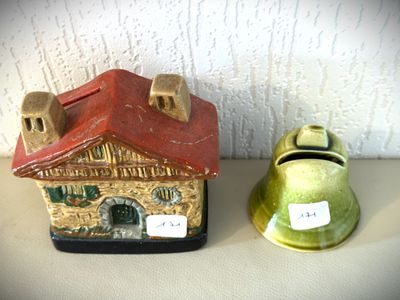 une petite clochette posée sur une table, à côté d'une petite maison