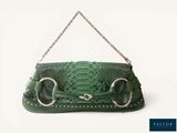 un sac à main vert muni d'une chaîne suspendue à sa poignée