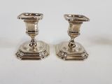 pair of silver candlesticks on a white background