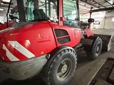 a red tractor that is parked inside of a building