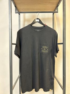 un t-shirt noir suspendu à un porte-vêtements en métal dans une pièce