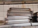 a stack of pans sitting on a shelf in a kitchen