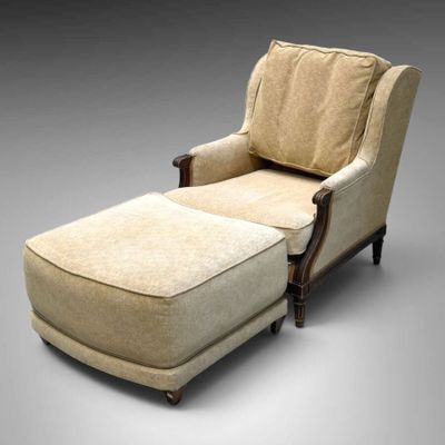 un fauteuil rembourré et un repose-pieds avec un coussin rembourré beige