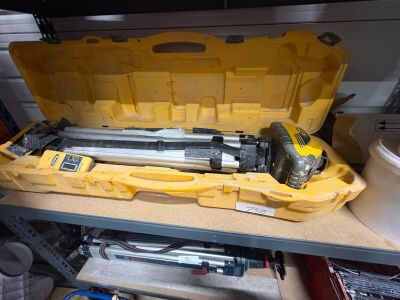 une boîte à outils jaune contenant des outils, posée sur une étagère