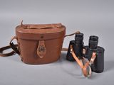 étui à appareil photo en cuir marron avec deux jumelles sur fond blanc