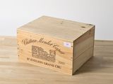 La caisse en bois contient une bouteille de vin posée sur une table en bois.