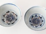 pair of blue and white bowls with designs on them on a white surface