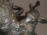 a bronze statue of a deer and a bird on a table