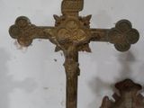 une croix sur une table avec une statue en arrière-plan