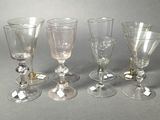 six wine glasses are lined up on a gray surface
