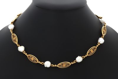 une photo d'un collier de perles porté par un mannequin