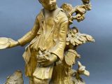 bronze figurine of a boy with a bird on a tree stump