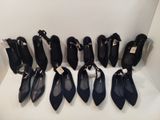 Neuf paires de chaussures noires sont alignées sur une étagère