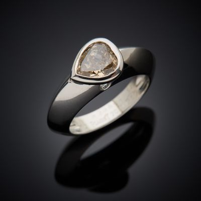 a close up of a ring with a white diamond on it