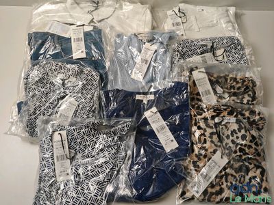 a group of men ' s shirts in plastic bags sitting on top of a table