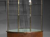 une vitrine en verre avec un socle en bois et des étagères en verre