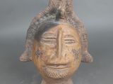 une image représentant une sculpture en bois représentant une tête d'homme