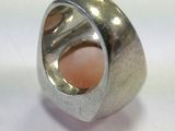 a silver ring with a pink stone inside of it