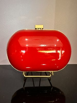 un sac à main rouge posé sur une table noire