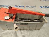 an orange pipe cutter sitting on top of a metal container