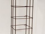 a black metal shelf with four shelves on top of it
