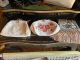 three purses sitting on a table with a laptop on it