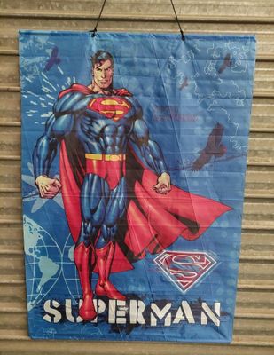 a close up of a superman poster hanging on a wall