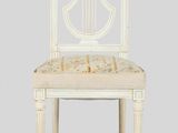a white wooden chair with a beige upholstered seat