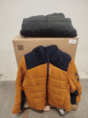 Deux vestes sont empilées sur une boîte en carton dans un entrepôt
