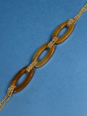 a close up of a bracelet with a chain on a blue surface