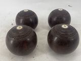 three dark brown wooden balls on a white surface