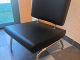 une chaise noire posée devant une porte