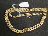 a close up of a gold chain with a tag on it