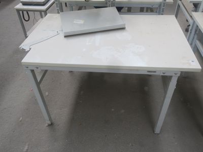 une table blanche sur laquelle est posé un ordinateur portable