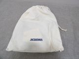 a white bag with a name on it on a bed