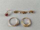three gold rings and a pair of earrings are sitting on a table