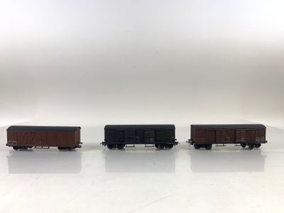trois petits trains sont alignés les uns à côté des autres sur une surface blanche