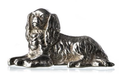 figurine de chien argentée assise sur une surface blanche, sur fond blanc