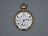 une montre de poche en or accrochée au mur
