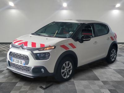 une voiture blanche avec des bandes rouges garée dans un garage
