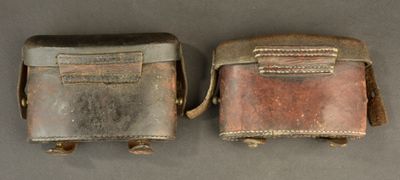 two pieces of silver and brown leather on a gray surface